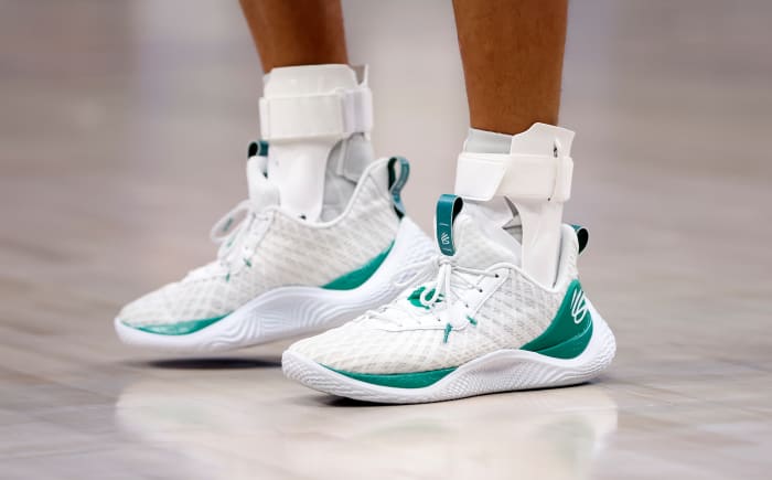 View of white and green Curry shoes.